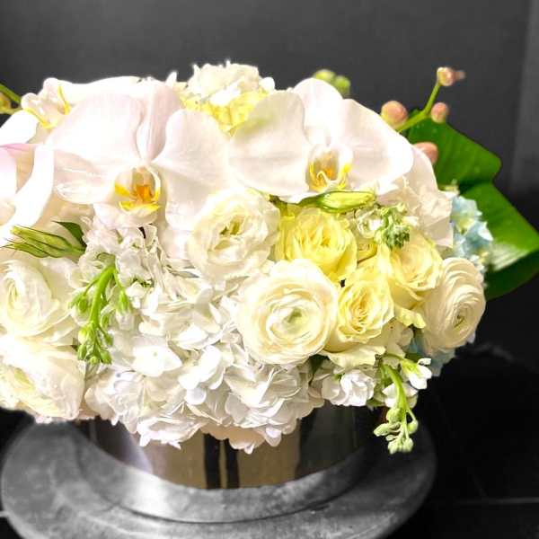 White and pale yellow bouquet with orchids and roses in a vase