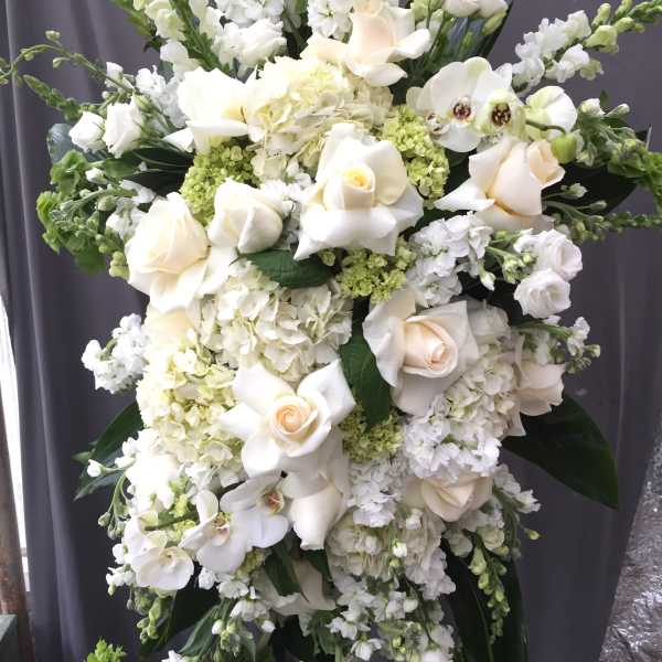 Large white floral spray with roses, orchids, and hydrangeas