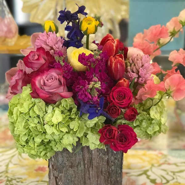 Colorful mixed flower arrangement in a rustic wooden container