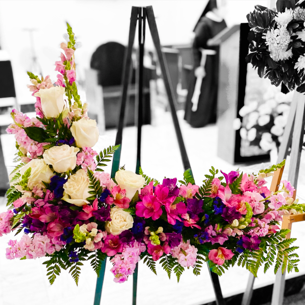 Colorful floral arrangement on an easel with roses and pink blooms