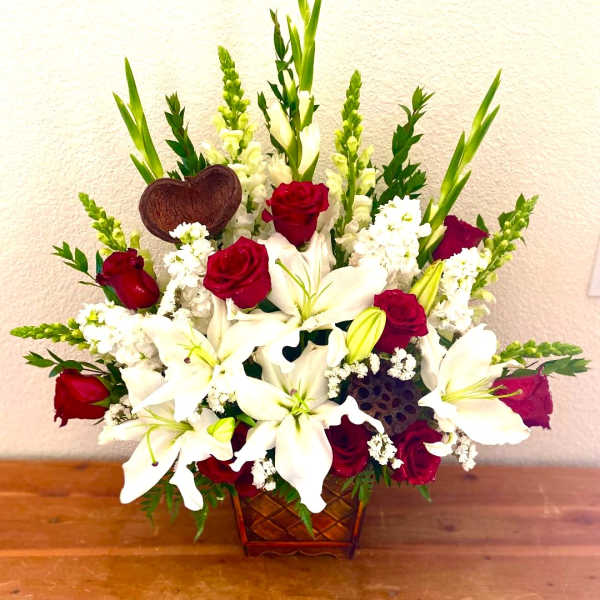 Red roses and white lilies in a woven basket arrangement