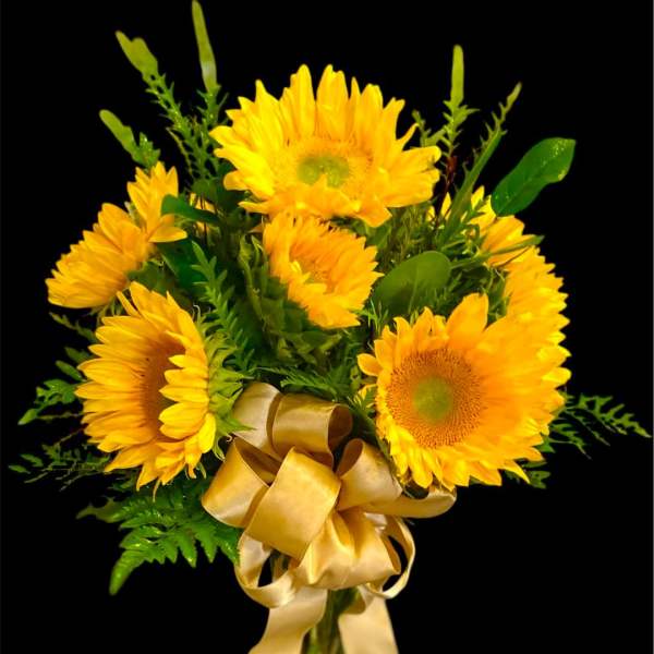 Bouquet of yellow sunflowers with a gold ribbon in a glass vase
