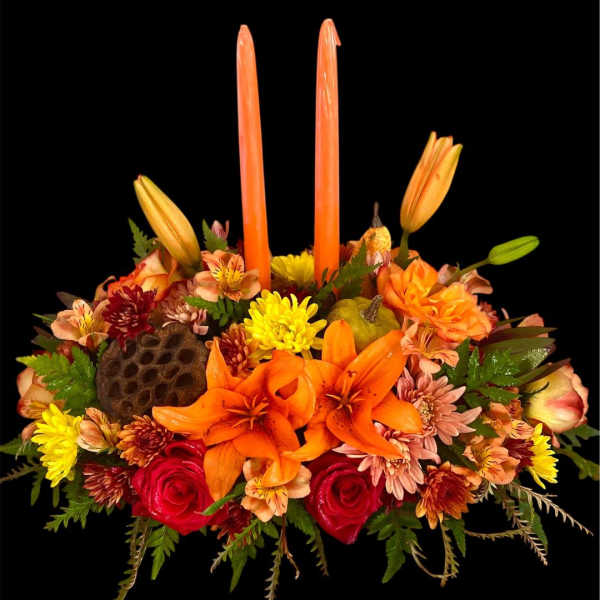 Orange and red floral centerpiece with tall candles