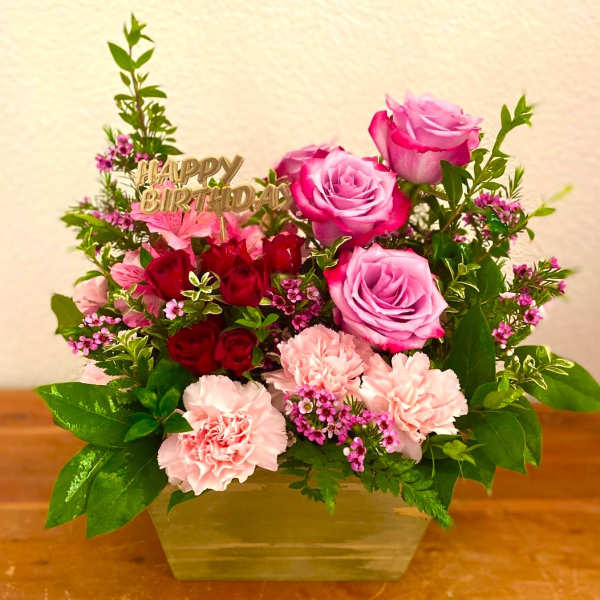 Pink and red rose bouquet with carnations in a vase and a Happy Birthday topper