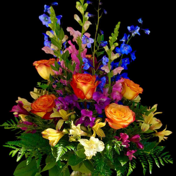 Colorful bouquet of roses, snapdragons, and alstroemeria in a glass vase
