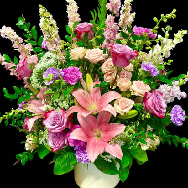 Pink and lavender floral arrangement in a white vase