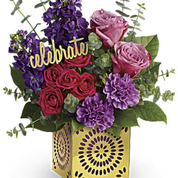 Pink and purple rose bouquet in a gold decorative box with a "celebrate" pick