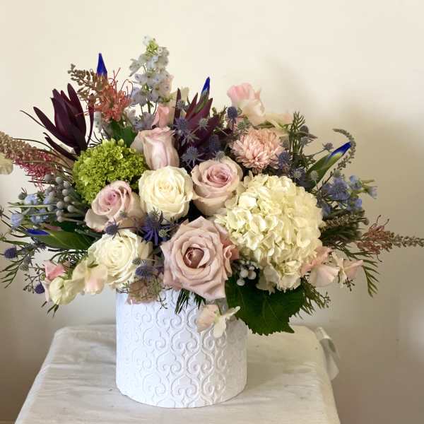Mixed bouquet of pastel roses and hydrangea in a white vase