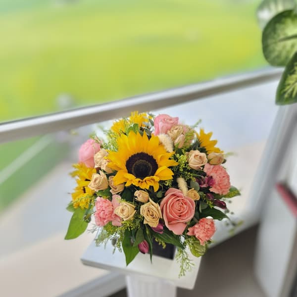 Bouquet with a sunflower, pink roses, and beige spray roses