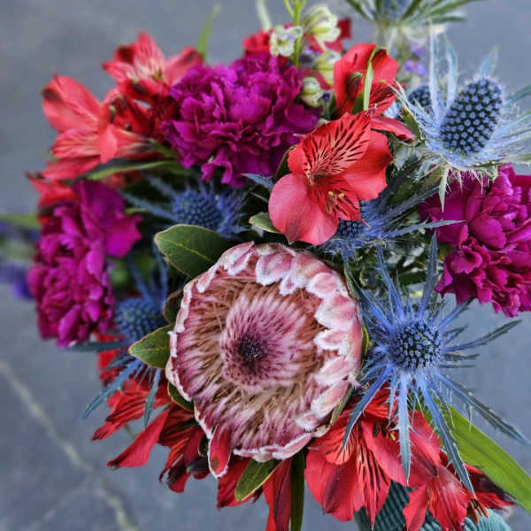 Bright mixed bouquet with magenta, red, and blue flowers