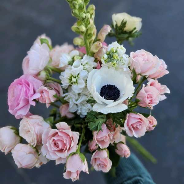 Bouquet of pink roses and white anemones with a tall green spike