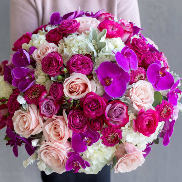 Round bouquet of pink roses, white hydrangeas, and purple orchids