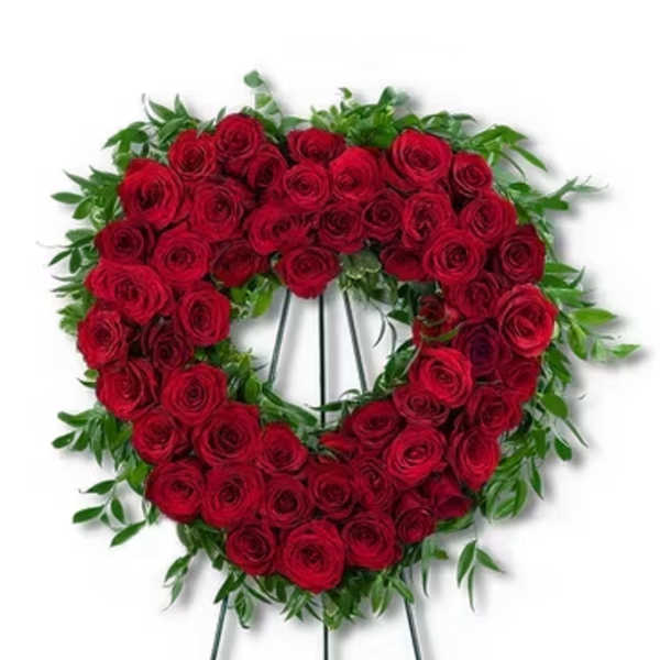 Heart-shaped wreath of red roses on a metal easel stand