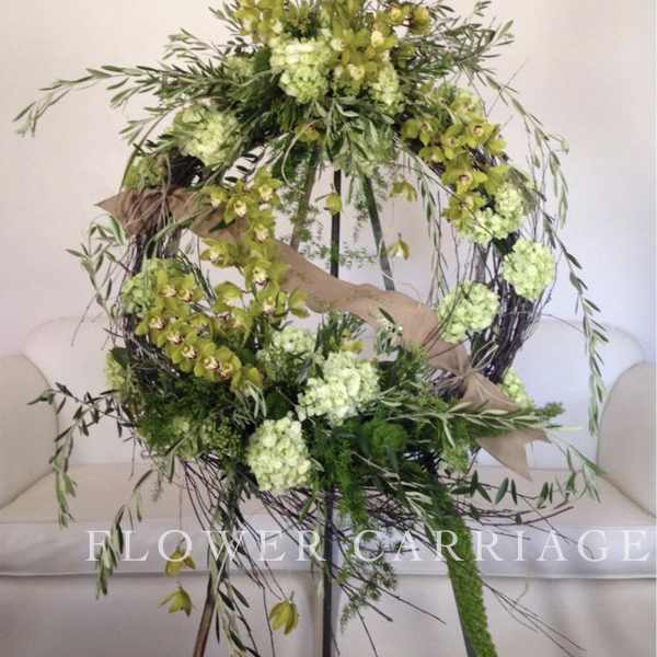 Large circular floral wreath with green orchids and pale green blooms