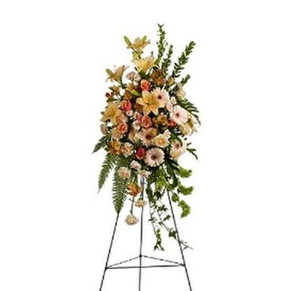 Standing floral spray on an easel with pale mixed flowers and greenery