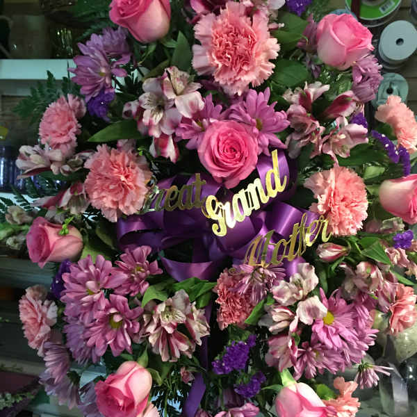Pink and purple floral wreath with roses and ribbon