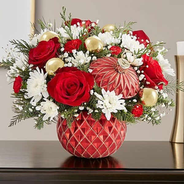 Red roses and white daisies in a red patterned vase with gold ornaments