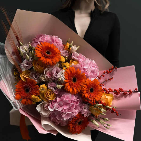 Large bouquet of orange gerbera daisies and pink hydrangeas wrapped in pink paper