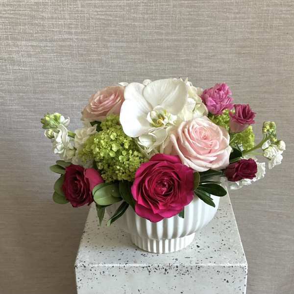 Bouquet of pink and white roses in a white ceramic vase