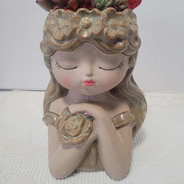 Ceramic girl planter with succulent arrangement on top