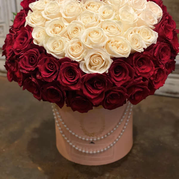Heart-shaped bouquet of red and white roses in a pink hatbox