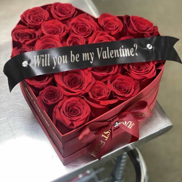 Heart-shaped box of red roses with a Valentine ribbon