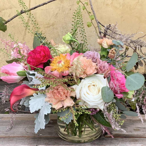 Mixed bouquet in a clear glass vase with pink, white, and peach flowers