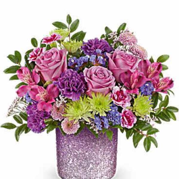 Mixed pink and purple flower arrangement in a glittery lavender vase