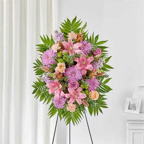 Standing floral spray with pink lilies, roses, and purple blooms