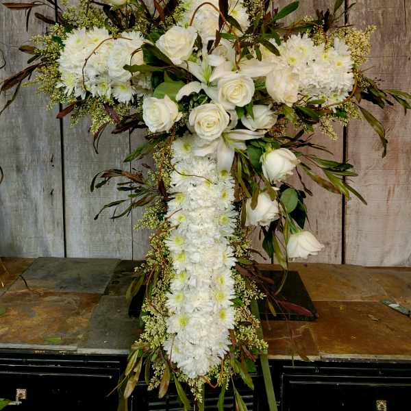 White floral cross arrangement with roses and daisies