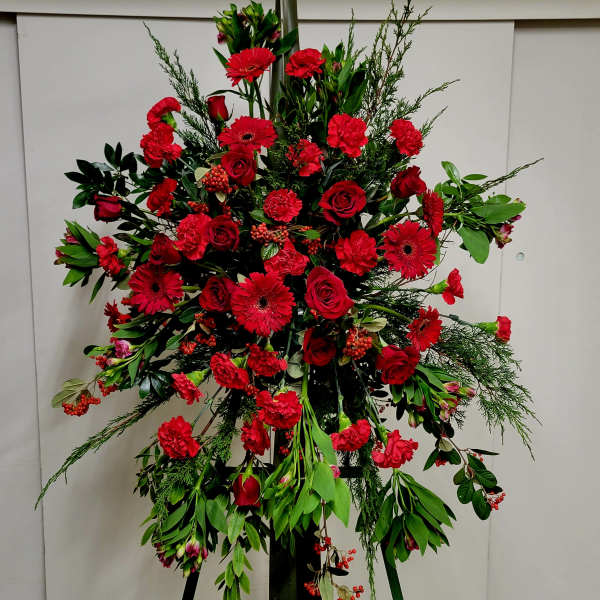 Large red floral standing spray on an easel