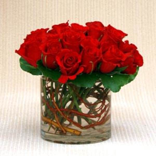 Red roses arranged in a clear glass vase