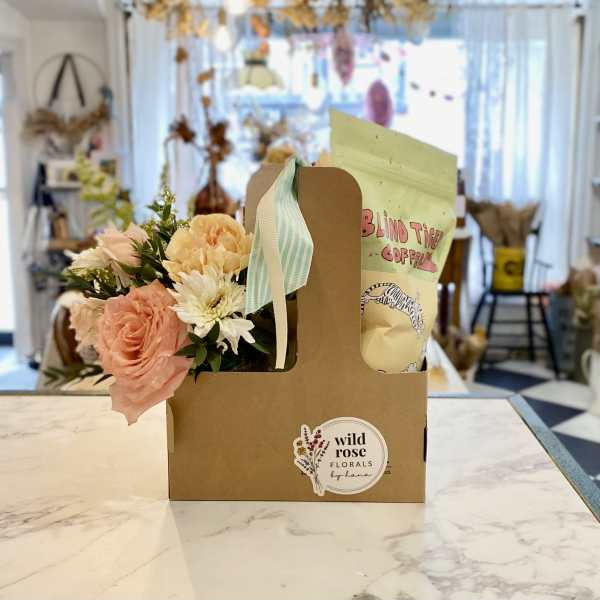 Flower arrangement and coffee bag in a cardboard gift carrier
