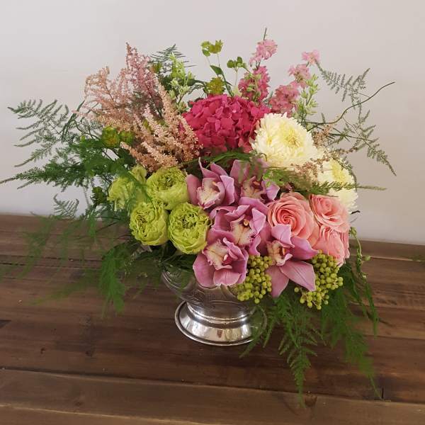 Mixed bouquet in a silver vase with pink, green, and white flowers