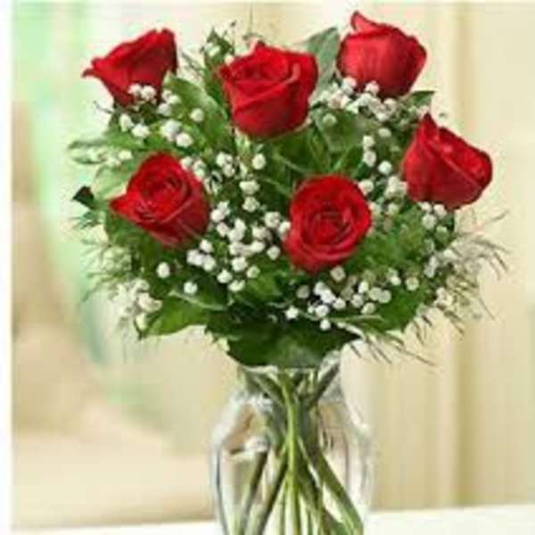 Bouquet of red roses and baby's breath in a clear glass vase