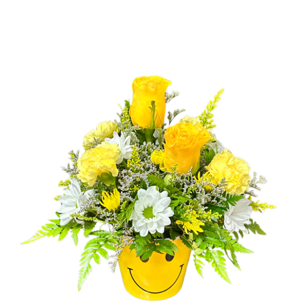 Yellow and white flower arrangement in a smiley-face pot