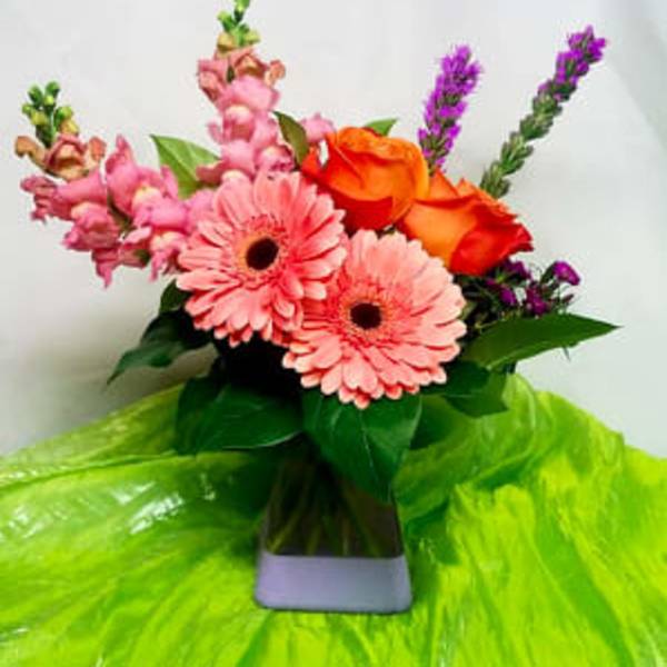 Pink gerbera daisies and orange roses in a vase