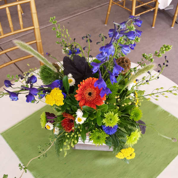Colorful mixed flower centerpiece in a low white container