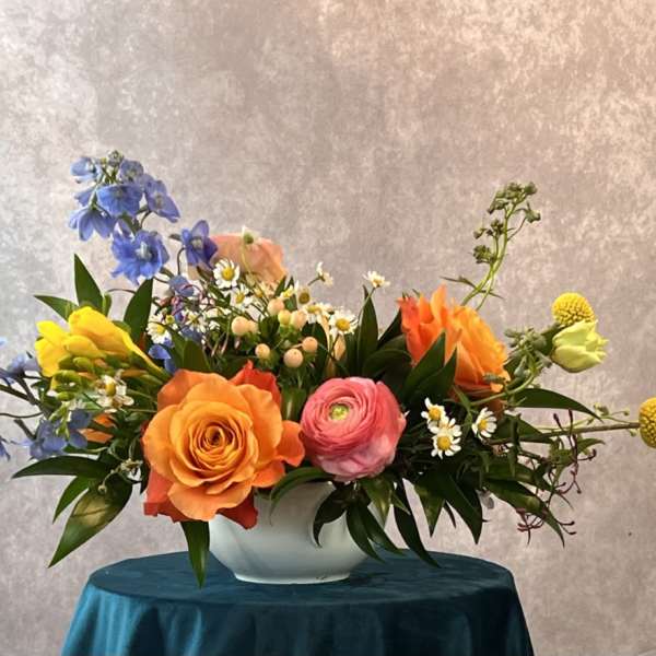 Colorful mixed flower arrangement in a white bowl vase
