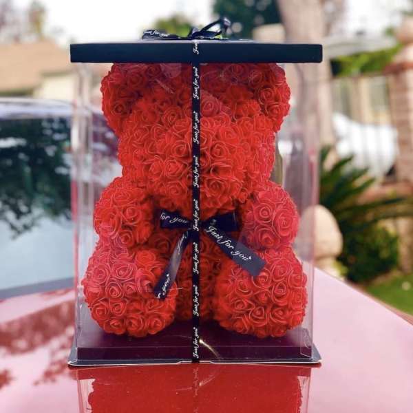 Red rose teddy bear in a clear display box with black base and ribbon