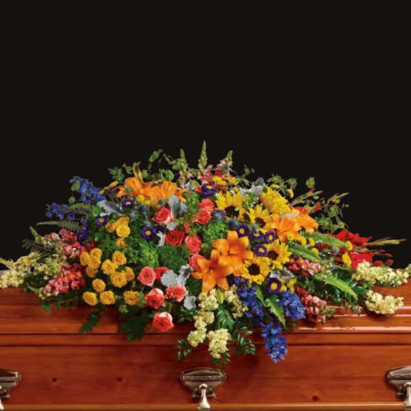 Colorful floral casket spray with roses, lilies, and daisies