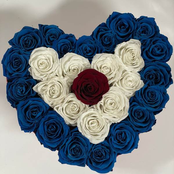 Heart-shaped arrangement of blue, white, and red roses