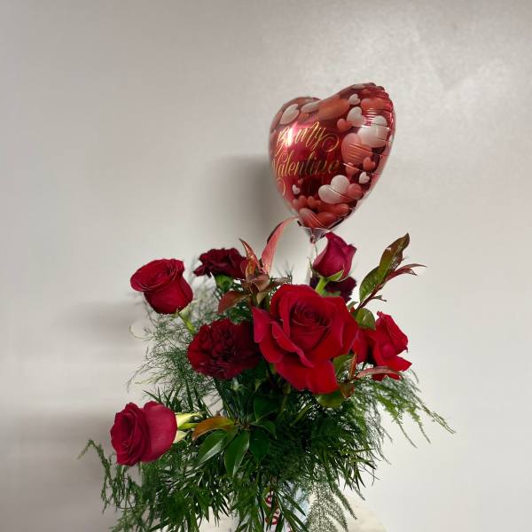 Red roses in a vase with a heart-shaped Valentine balloon