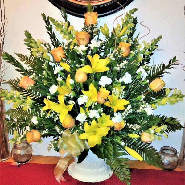 Yellow lilies and peach roses in a white vase