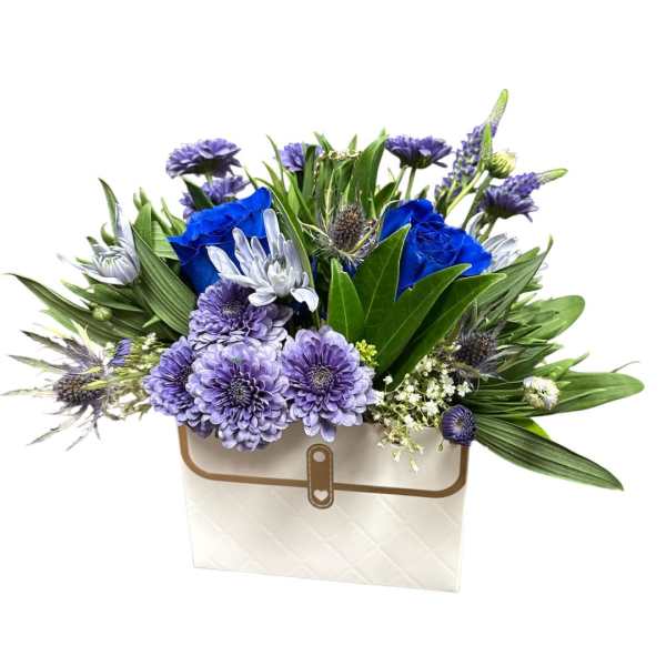 Blue and lavender flower arrangement in a white gift box