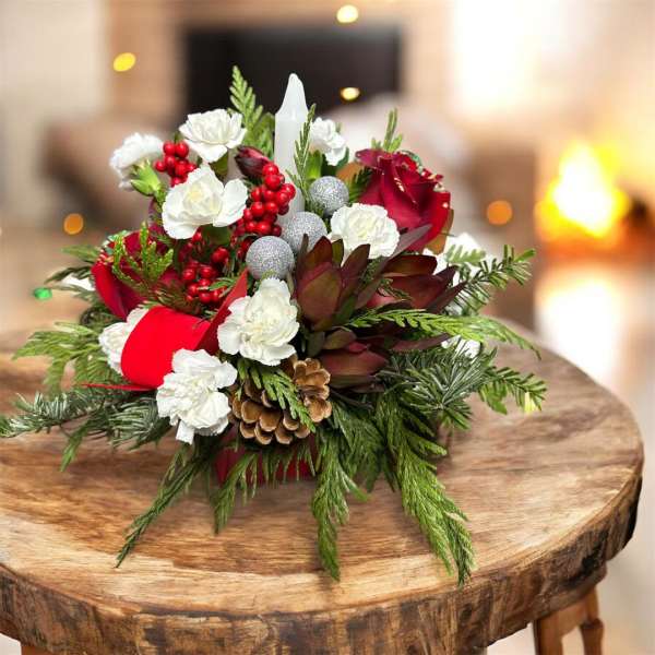 Christmas centerpiece with red roses, white carnations, and pinecones