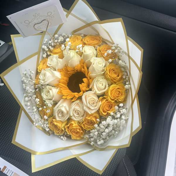 Bouquet of yellow and white roses with a sunflower center
