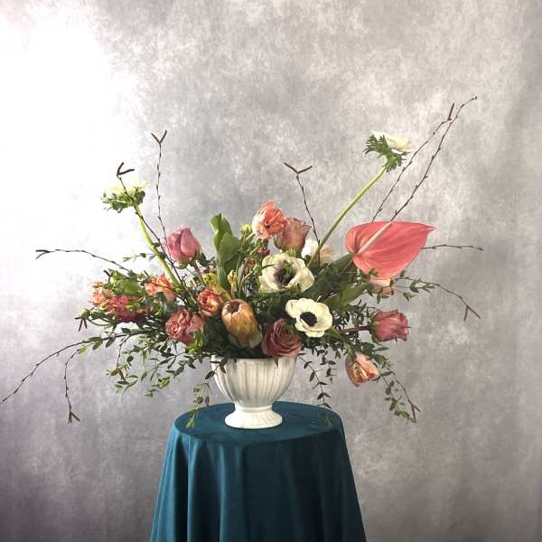 Large mixed floral arrangement in a white urn vase