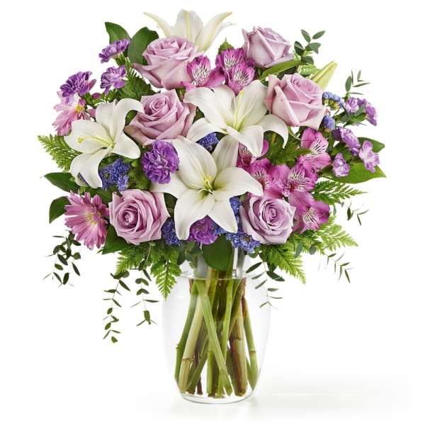 Bouquet of pink roses and white lilies in a clear glass vase