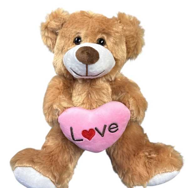 Brown teddy bear holding a pink heart with the word Love